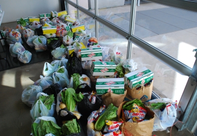 Bags of food bank groceries gathered in the lobby waiting for collection by residents. 