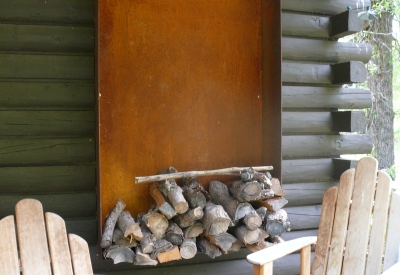 Two chairs and firewood on the porch of Redstone Cabin in Redstone Colorado.