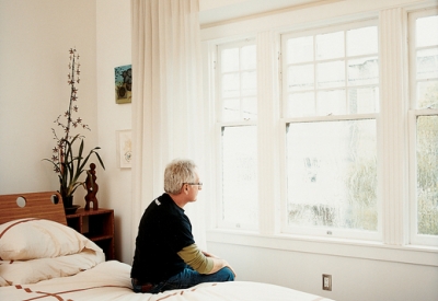 Man sitting on the bed in the master bedroom at Shotwell Design Lab in San Francisco.