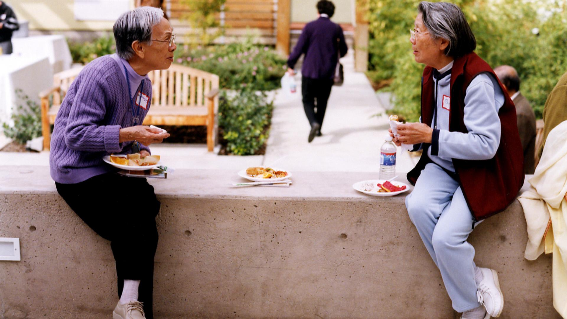 Two residents sitting in the courtyard at Mabuhay Court in San Jose, Ca.