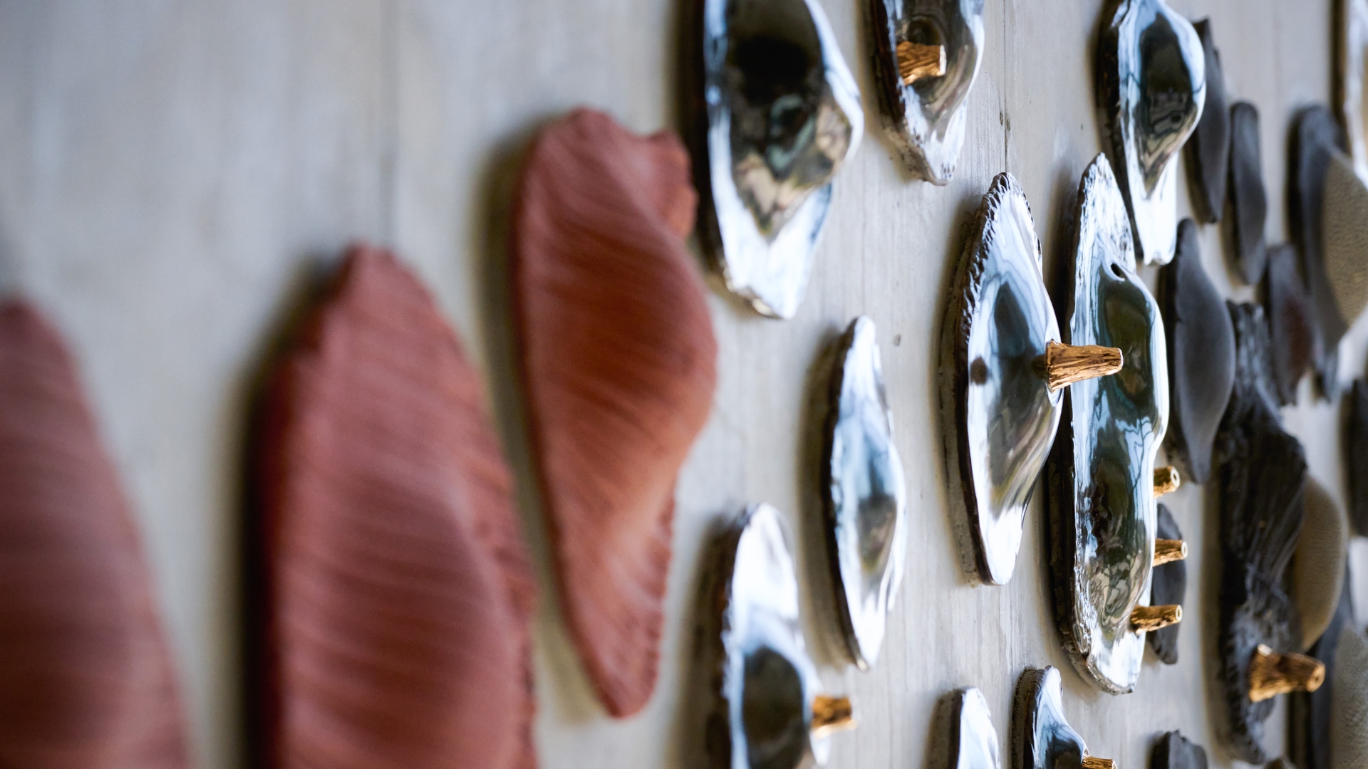 Closeup view of textured ceramic discs affixed to a concrete wall