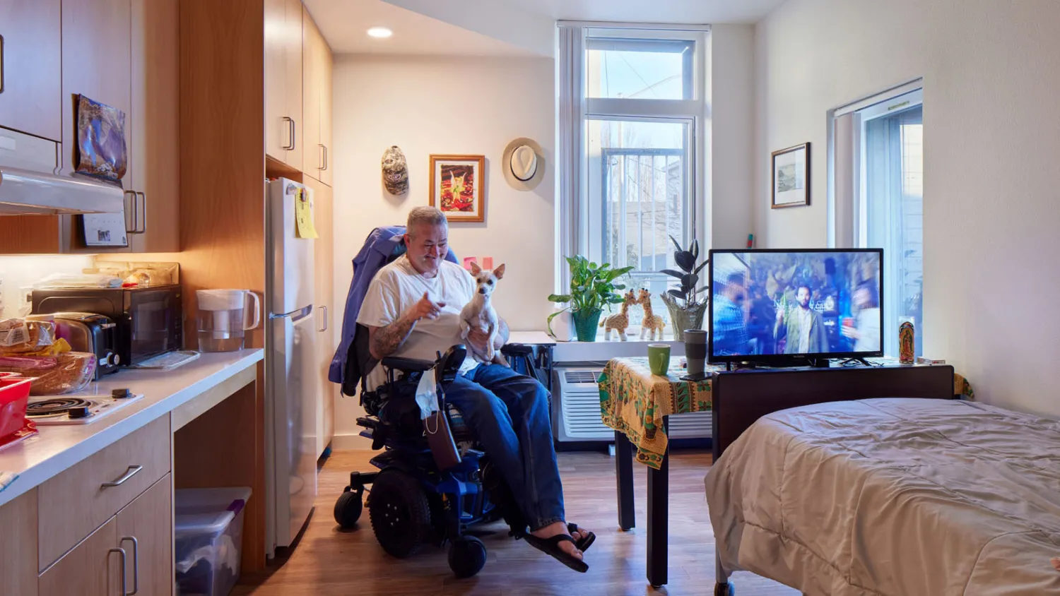 Resident sitting in his wheel chair inside his unit at Tahanan Supportive Housing in San Francisco.