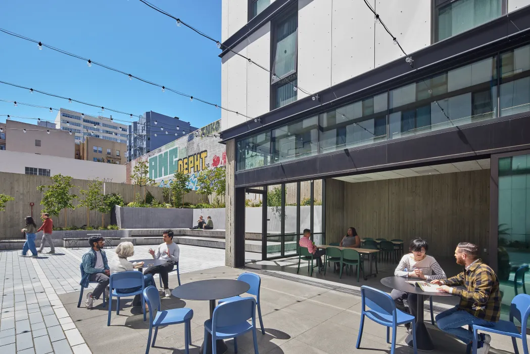 People sitting at tables out in the courtyard at 555 Larkin in San Francisco.