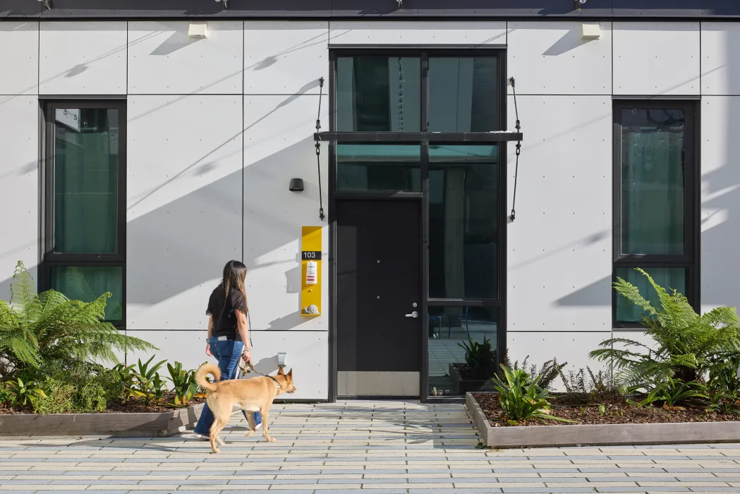 Woman walking her dog in the courtyard of 555 Larkin in San Francisco.