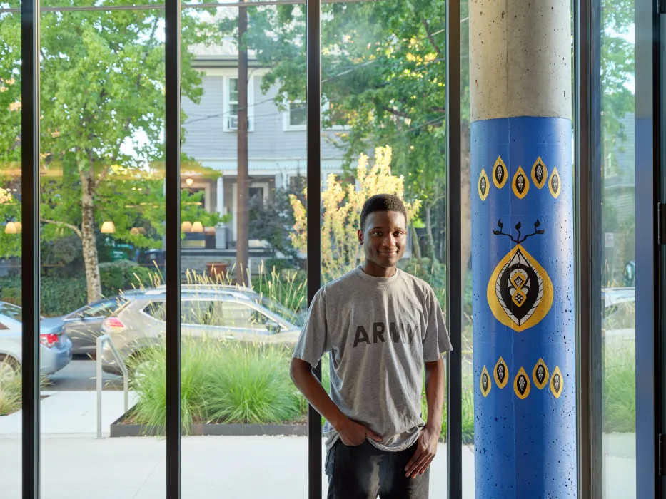 Young man posing in the entry lounge of Africatown Plaza in Seattle.